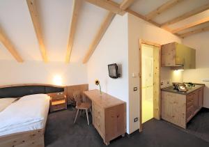 Col di VillaResidence Alpenrose的一间带床和书桌的卧室和厨房