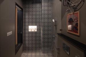a bathroom with a shower with a tile wall at Inara House in Agra +52 photos