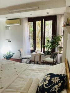 ein Schlafzimmer mit einem Bett, einem Tisch und Stühlen in der Unterkunft L'e'tage House in Hanoi