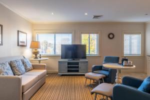 un salon avec un canapé et une télévision à écran plat dans l'établissement Juniper Hill Inn, à Ogunquit