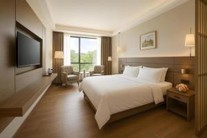 ein Hotelzimmer mit Bett und Fernseher in der Unterkunft Hanyong Hotel Shenzhen International Exhibition Center in Fenghuangwei + 148 Fotos