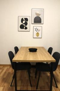 a wooden table with chairs in a room with paintings at Cosy Living in Vallendar Central and Peaceful in Vallendar