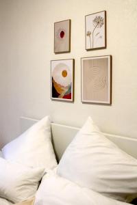 a bedroom with four pictures on the wall above a bed at Cosy Living in Vallendar Central and Peaceful in Vallendar +7 photos