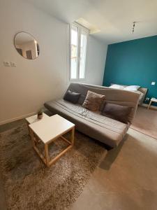een woonkamer met een bank en een tafel bij Appartement La Gare-rdc in Saint-Gaudens