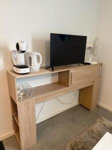 een tv op een houten standaard met een televisie bij Appartement La Gare-rdc in Saint-Gaudens
