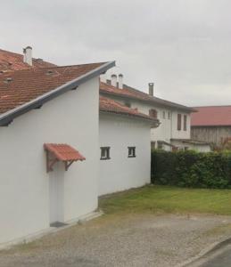 een wit gebouw met een rood dak en een aantal huizen bij Appartement La Gare-rdc in Saint-Gaudens