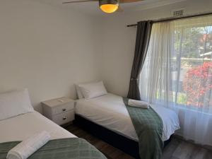 ein Schlafzimmer mit zwei Einzelbetten und einem Fenster in der Unterkunft 230 Laguna La Crete in Margate