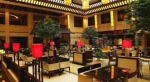 ein Restaurant mit Tischen, Stühlen und roten Lampen in der Unterkunft Cixi Hangzhou Bay Hotel in Hejiao