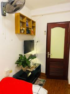 Zimmer mit einem Bett und einer Tür mit einer Pflanze in der Unterkunft L'e'tage House in Hanoi