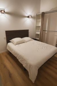 een slaapkamer met een groot bed met witte lakens bij Appart Hotel 23 - Le Cocon Creusois 2 in Guéret