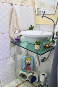 un bagno con un tavolo di vetro con un lavandino di Cantinho Zen, Ponte do Imaruim -Palhoça-SC a Palhoça