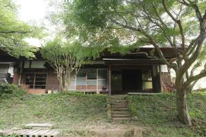 ein Haus mit einem Baum und einer Treppe davor in der Unterkunft BoBuchi in Ichihara