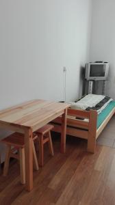 a wooden table in a room with a wooden floor at Hostel Sosnowiec in Sosnowiec
