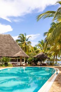 een zwembad voor een resort met palmbomen bij JAZ Adonia in Uroa