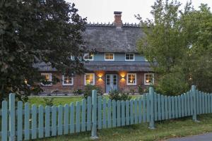 a white picket fence in front of a house at Ferienwohnung Captains Lodge Steinbergkirche in Steinbergkirche