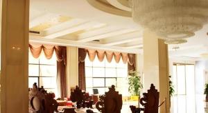 een lobby met ramen en een kamer met tafels bij Jie Hao Royal Hotel in Fenghuangwei