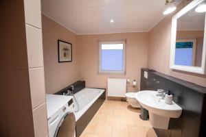un bagno con vasca, WC e lavandino di Ferienwohnung Captains Lodge Steinbergkirche a Steinbergkirche Altre 11 foto
