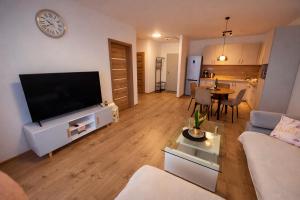 a living room with a flat screen tv on a entertainment center at Modern Smart Apartment, Garage & City View in Lipany +7 photos