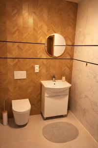 a bathroom with a sink and a toilet and a mirror at Modern Smart Apartment, Garage & City View in Lipany