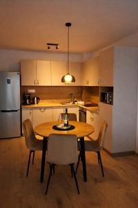 a kitchen with a table and chairs and a refrigerator at Modern Smart Apartment, Garage & City View in Lipany