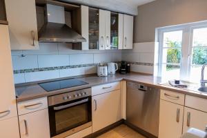 een keuken met witte kasten en een spoelbak bij Ferienwohnung Backbord Steinbergkirche in Steinbergkirche