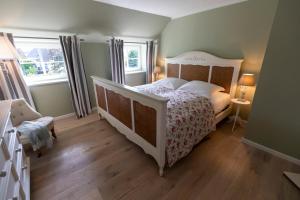 een slaapkamer met een wit bed en een houten vloer bij Ferienwohnung Backbord Steinbergkirche in Steinbergkirche