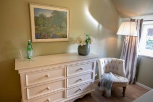 een slaapkamer met een dressoir en een vaas met bloemen bij Ferienwohnung Backbord Steinbergkirche in Steinbergkirche +22 foto's