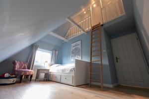 a bedroom with a bunk bed and a ladder at Ferienwohnung Backbord Steinbergkirche in Steinbergkirche +20 photos
