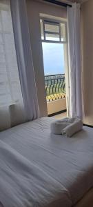 a bed with a window with a view of the ocean at Maple Lane Stays in Nakuru
