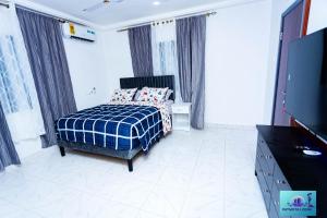 una camera da letto con un letto e una TV a schermo piatto di Ernest homes a Kwabenyan Altre 8 foto