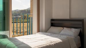 a bedroom with a bed and a large window at Gyeongju Gamposole Pension in Gyeongju