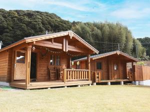 eine große Holzhütte mit Veranda in der Unterkunft Beverly Glamping - Vacation STAY 82305v in Kakegawa