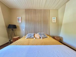 een slaapkamer met een groot bed met twee kussens bij Occitemps in Saint Julien Les Rosiers