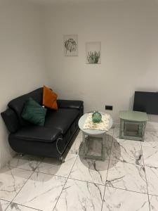 un soggiorno con un divano nero e un tavolo di The Cotes Suite by Nestura a Loughborough