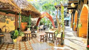 an outdoor patio with tables and chairs and a restaurant at MILAN Boutique Garden in Vung Tau