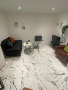 un soggiorno con un divano e un tavolo di The Cotes Suite by Nestura a Loughborough