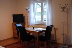 a room with a table with chairs and a window at Ferienwohnung Bio-Bauernhof Schuwerk in Isny im Allgäu +3 photos