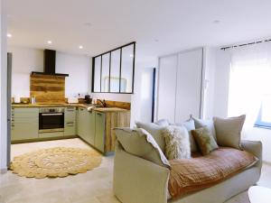 ein Wohnzimmer mit Sofa und eine Küche in der Unterkunft L'échappée Bulles - T3 - Jacuzzi in Auch