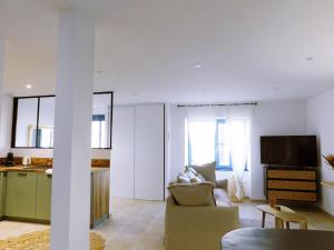 ein Wohnzimmer mit Sofa und eine Küche in der Unterkunft L'échappée Bulles - T3 - Jacuzzi in Auch