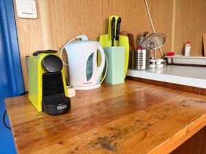 a kitchen counter top with a cutting board and appliances at GreenPark Tiny House, Garden Terrace & Parking in Bekecs