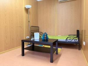 a room with a table and a bed with a lamp at GreenPark Tiny House, Garden Terrace & Parking in Bekecs