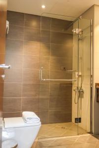 Un baño con inodoro y ducha de cristal. en Al Riyadh Hotel Apartments, en Abu Dabi