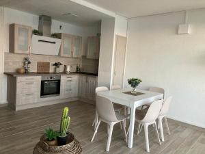 een keuken en eetkamer met een witte tafel en stoelen bij Exceptional sea view! Comfortable apartment in La Celle-sous-Gouzon +27 foto's