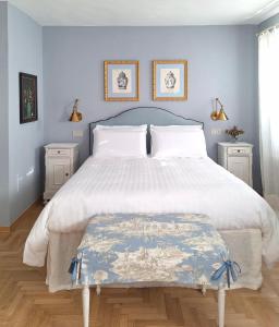 ein Schlafzimmer mit einem großen weißen Bett mit zwei Nachttischen in der Unterkunft al piccolo giardino in Vittorio Veneto