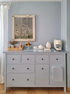 eine weiße Kommode in einem Zimmer mit blauer Wand in der Unterkunft al piccolo giardino in Vittorio Veneto