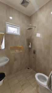 ein Badezimmer mit Toilette und Waschbecken in der Unterkunft Villa Dalia Puncak H11-11 in Cikundul