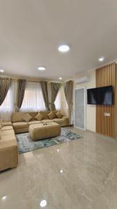 ein großes Wohnzimmer mit einem Sofa und einem Flachbild-TV in der Unterkunft Villa Dalia Puncak H11-11 in Cikundul + 37 Fotos