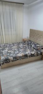 una camera da letto con un letto con copriletto floreale di E&A apartments a Târgu-Mureş