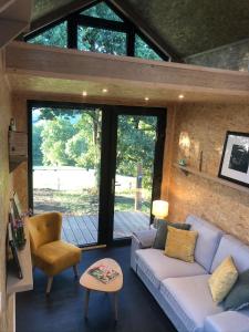a living room with a couch and a chair at Domaine de Hurlevent - Tiny House petite maison écologique in Aywaille