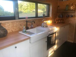 a kitchen with a white sink and a window at Domaine de Hurlevent - Tiny House petite maison écologique in Aywaille